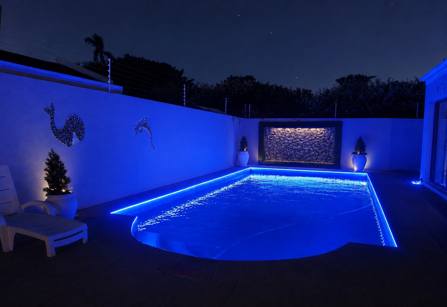 Pool at night with calm blue perimeter lighting
